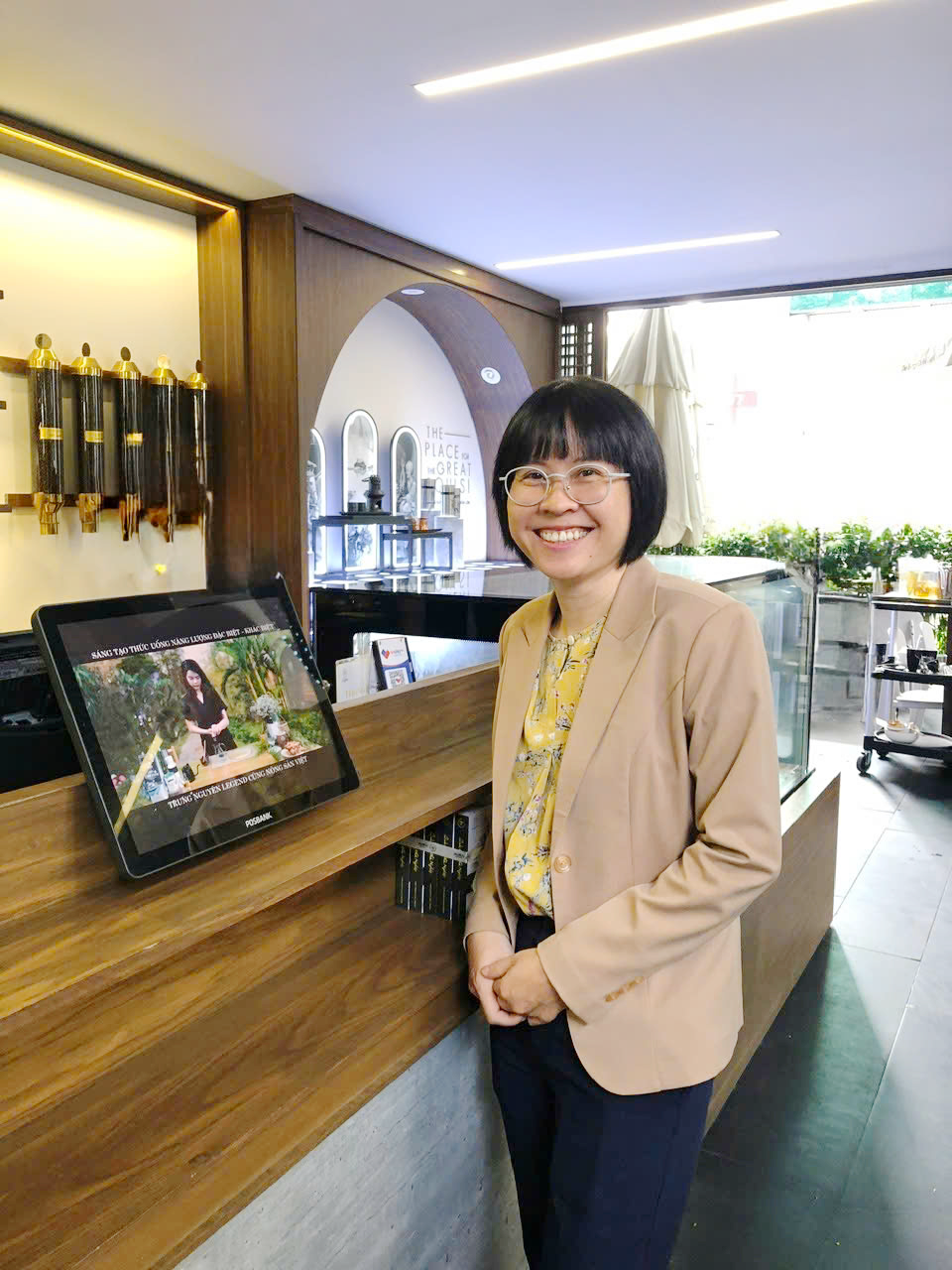 Business professional beside a point-of-sale system in a café